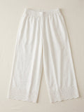 White cotton palazzo pants with scalloped floral embroidered hem, flat lay