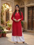 model wearing red georgette chikankari kurti with geometric embroidery, paired with white palazzos